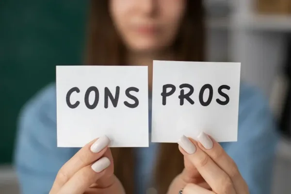 mulher segurando dois papeis com as palavras pros e cons